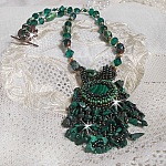 Pendentif Emerald avec un cabochon ovale en Malachite orn&eacute; de chips avec cristaux : perles rondes et toupies Emerald. S&rsquo;ajoute des perles en forme d&rsquo;olives. Brod&eacute;s sur fermoir en T. Un style Ethnique